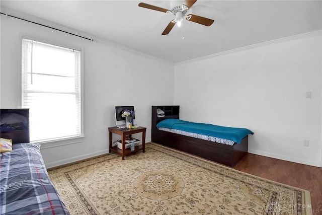 bedroom with a ceiling fan, baseboards, ornamental molding, and wood finished floors