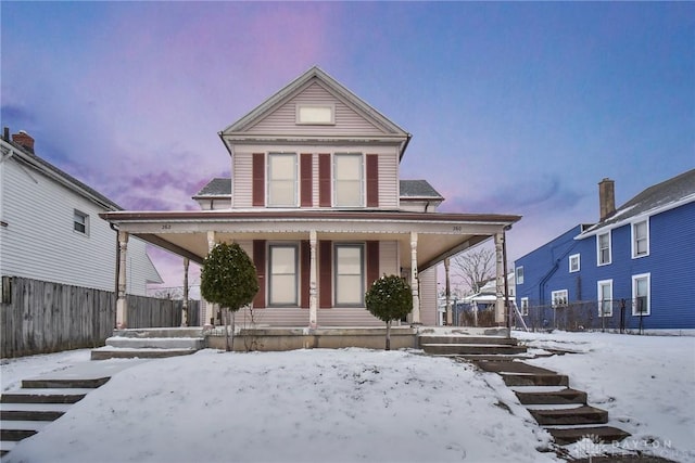 view of front facade with covered porch and fence