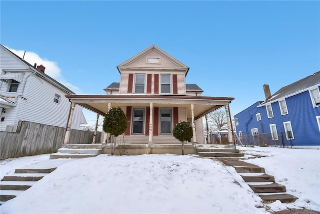 view of front of home featuring covered porch and fence