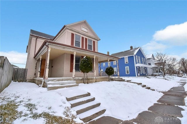 view of front of property featuring covered porch and fence