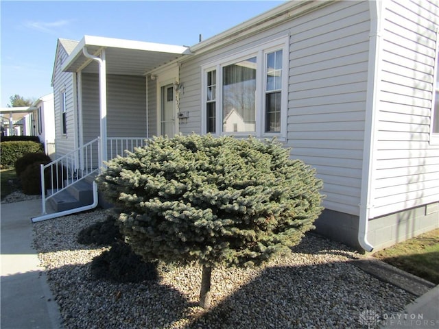 view of property exterior featuring covered porch and crawl space