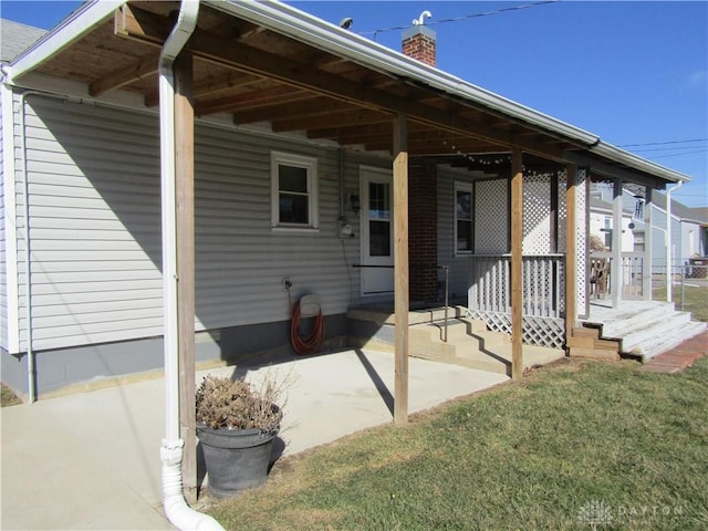 exterior space featuring a porch, an attached carport, and a chimney