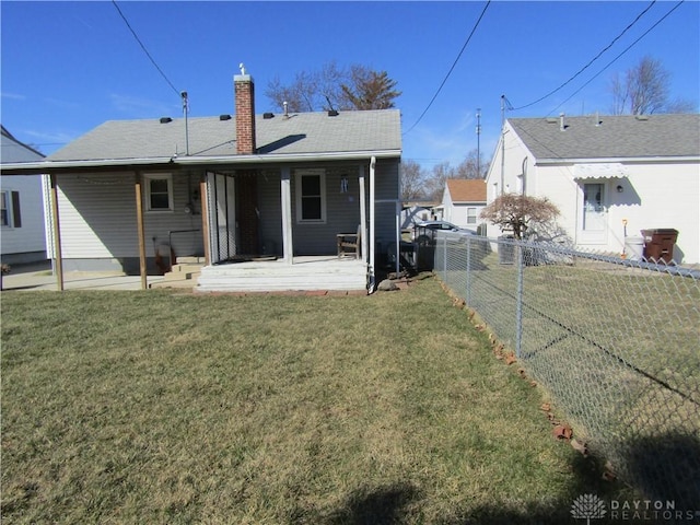 rear view of property featuring a lawn, a patio, a chimney, roof with shingles, and fence