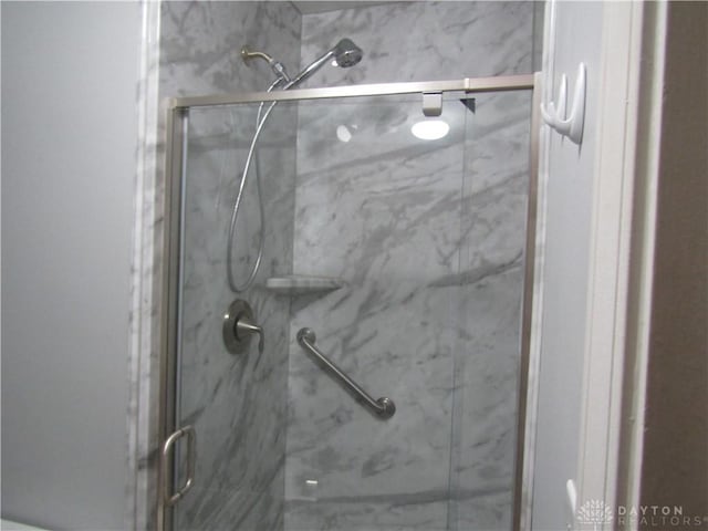 full bathroom featuring a marble finish shower