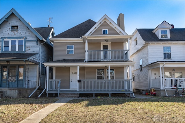 view of front of property featuring a porch, a front lawn, and a balcony