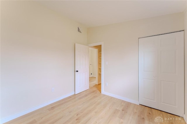 unfurnished bedroom featuring light wood-style flooring, visible vents, and baseboards