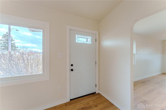 foyer entrance with baseboards, wood finished floors, and a healthy amount of sunlight