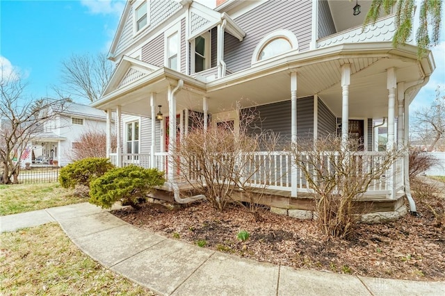 view of side of home featuring covered porch