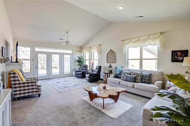 living room featuring lofted ceiling, visible vents, carpet flooring, and a ceiling fan