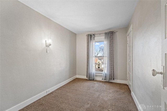 empty room featuring baseboards and carpet flooring