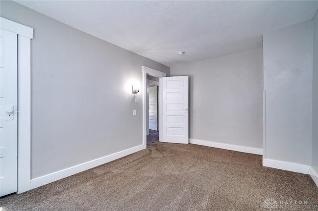 carpeted spare room with baseboards