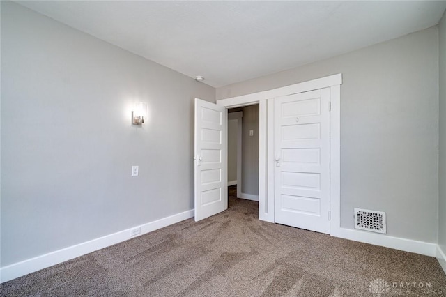 unfurnished bedroom with baseboards, visible vents, and carpet flooring