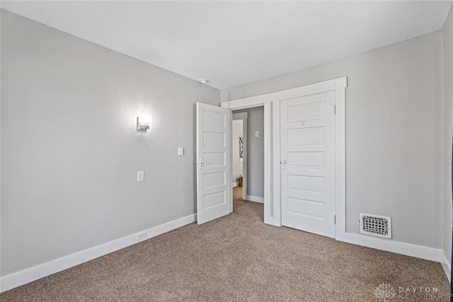 unfurnished bedroom featuring baseboards, visible vents, and carpet flooring