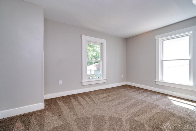 carpeted spare room featuring baseboards