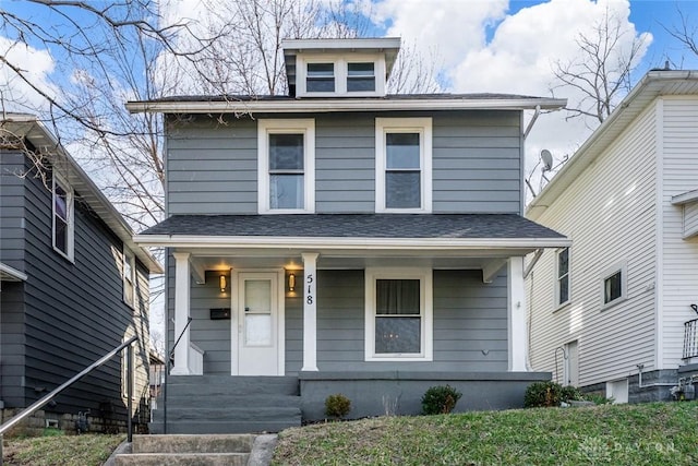 american foursquare style home with a porch and a shingled roof