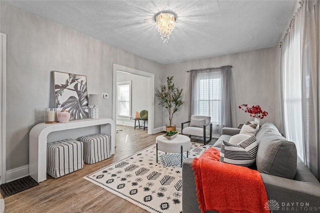 living area with plenty of natural light, baseboards, and wood finished floors