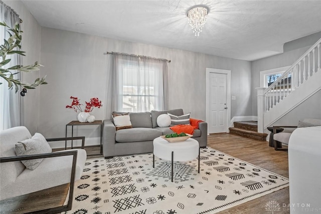 living room featuring a wealth of natural light, stairway, baseboards, and wood finished floors