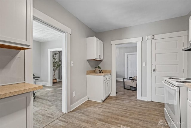 kitchen featuring white electric stove, light countertops, light wood-style floors, white cabinets, and baseboards