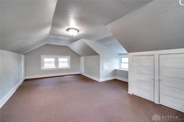 additional living space with carpet floors, a wealth of natural light, and baseboards