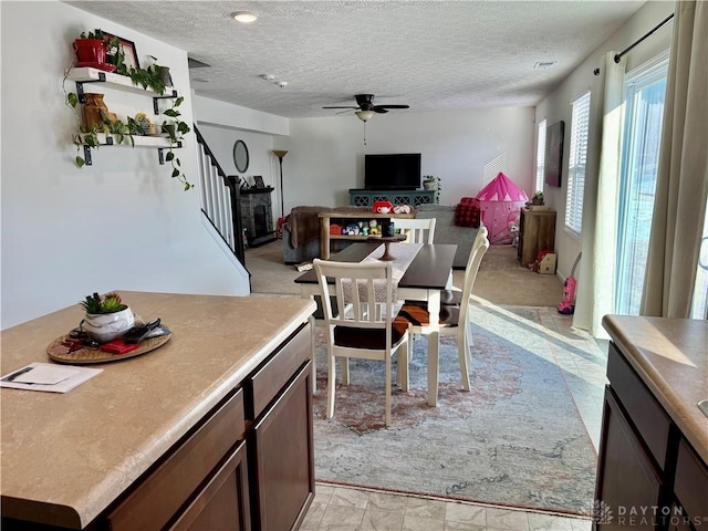 dining space with ceiling fan, stairs, and a textured ceiling