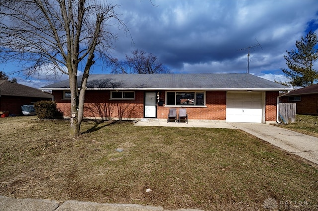 ranch-style home with driveway, brick siding, an attached garage, and a front yard