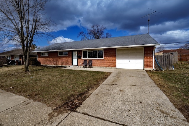 single story home with brick siding, concrete driveway, an attached garage, a front yard, and fence