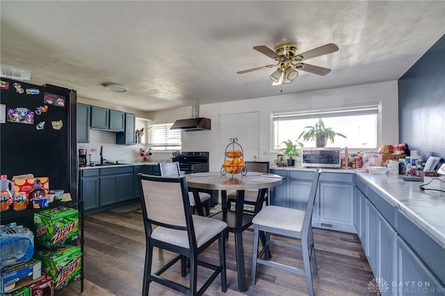 kitchen featuring appliances with stainless steel finishes, dark wood finished floors, light countertops, and exhaust hood