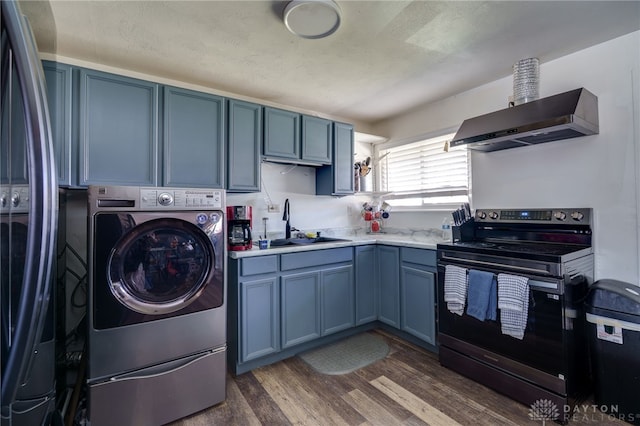 kitchen with blue cabinetry, washer / clothes dryer, light countertops, appliances with stainless steel finishes, and extractor fan