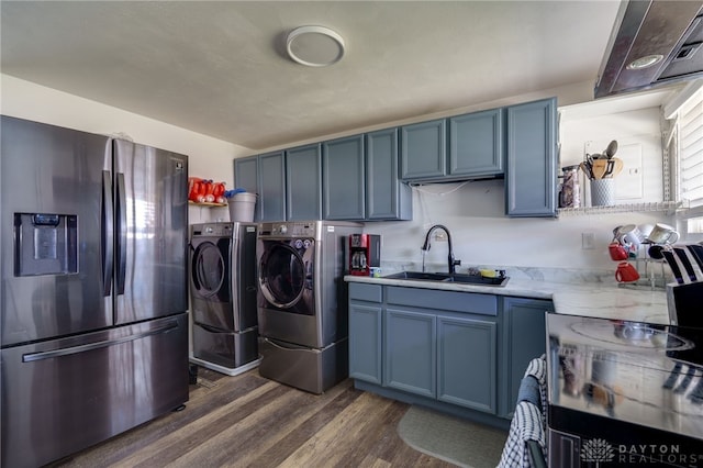 kitchen with stainless steel fridge with ice dispenser, dark wood-style floors, blue cabinets, washing machine and dryer, and a sink