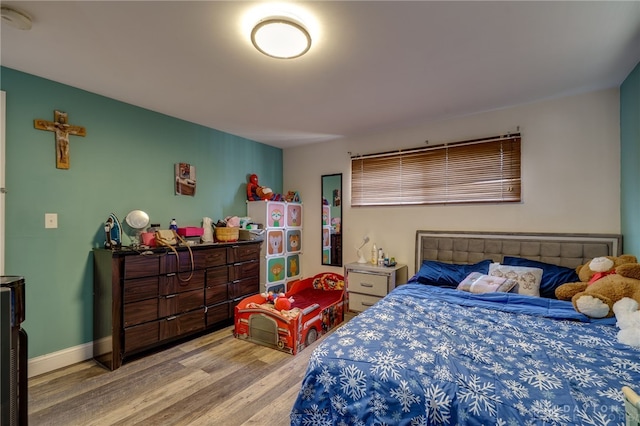 bedroom with baseboards and wood finished floors