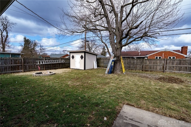 view of yard featuring a storage shed, an outdoor structure, a fenced backyard, and a fire pit