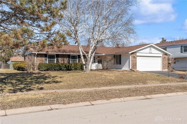 single story home with driveway, brick siding, and an attached garage