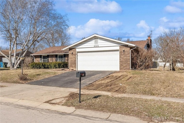 single story home with a garage, brick siding, driveway, and a chimney