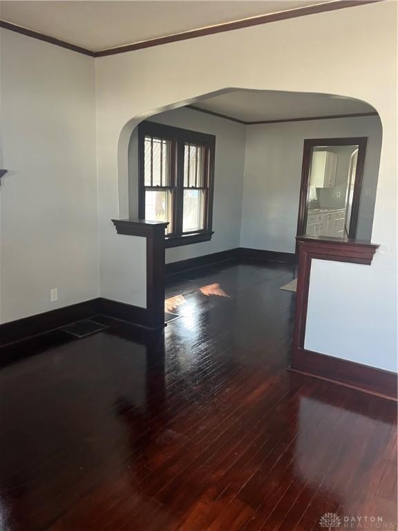 1205 Pursell Ave, Dayton, OH 45420 - unfurnished room with crown molding, baseboards, arched walkways, and wood finished floors