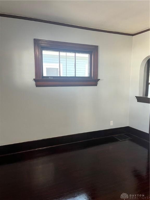1205 Pursell Ave, Dayton, OH 45420 - unfurnished room featuring baseboards, ornamental molding, arched walkways, and wood finished floors