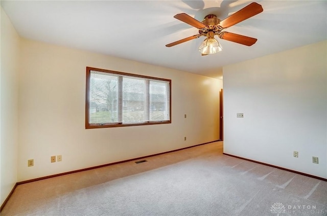 empty room featuring a ceiling fan, baseboards, visible vents, and carpet flooring