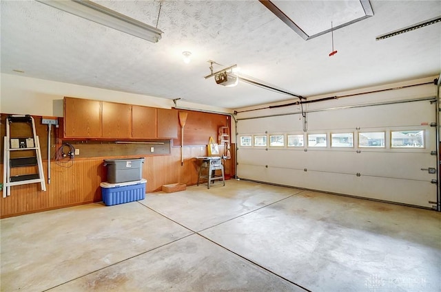 garage featuring wood walls and a garage door opener