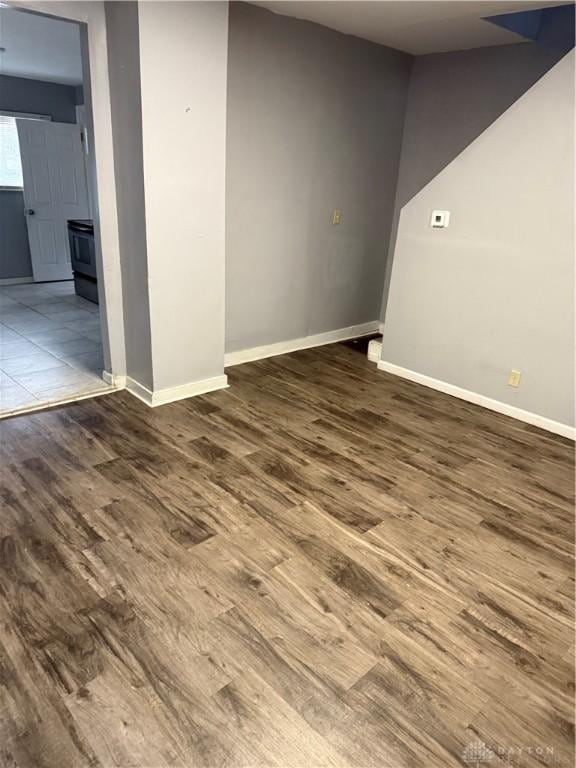 spare room featuring baseboards and wood finished floors