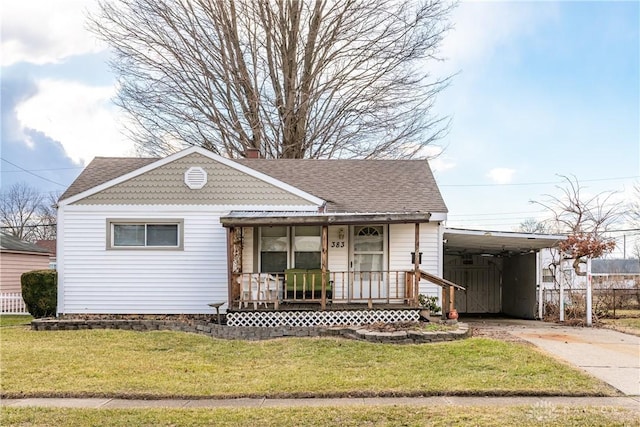 view of front of house with a chimney, concrete driveway, covered porch, a carport, and a front lawn