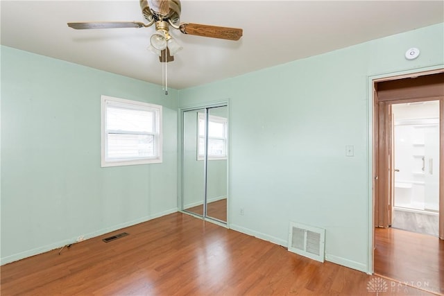 unfurnished bedroom featuring visible vents, baseboards, and wood finished floors