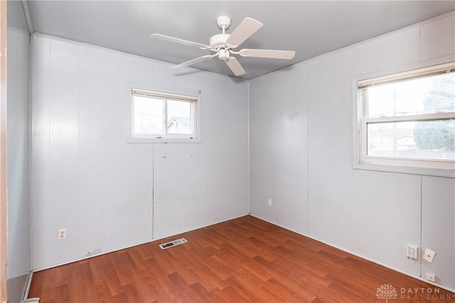 spare room featuring visible vents, ceiling fan, and wood finished floors