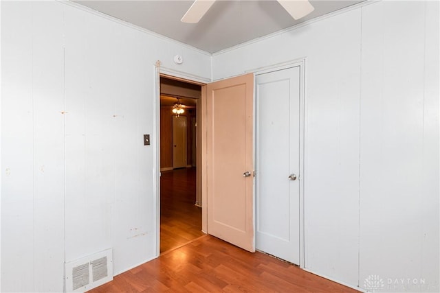 unfurnished bedroom with a ceiling fan, visible vents, and wood finished floors