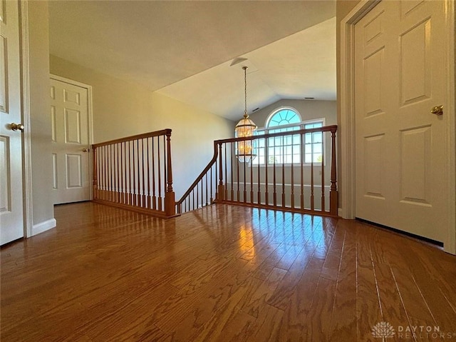 spare room featuring vaulted ceiling and wood finished floors