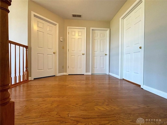 entrance foyer featuring visible vents, baseboards, and wood finished floors