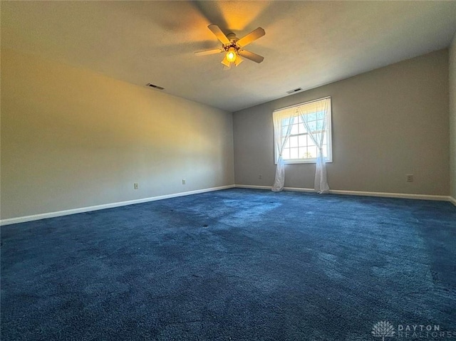 carpeted spare room featuring visible vents, ceiling fan, and baseboards