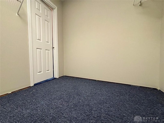 spare room with dark carpet