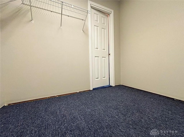 walk in closet featuring dark carpet