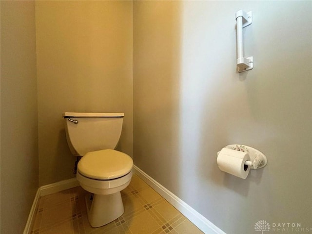 bathroom with toilet and baseboards