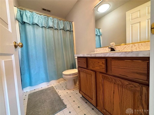 bathroom with visible vents, toilet, vanity, a shower with curtain, and tile patterned floors