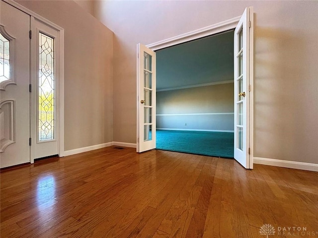 interior space featuring baseboards, wood finished floors, and french doors